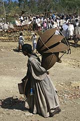 Woman in Ethiopia carrying cooking lids to market